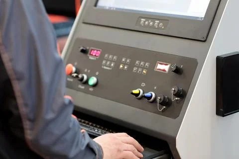 Worker controls metalworking CNC machine Stock Photos