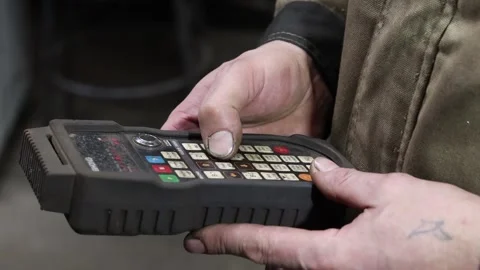 A worker controls the remote control of a lifting hoist at the factory Video stock 303721288