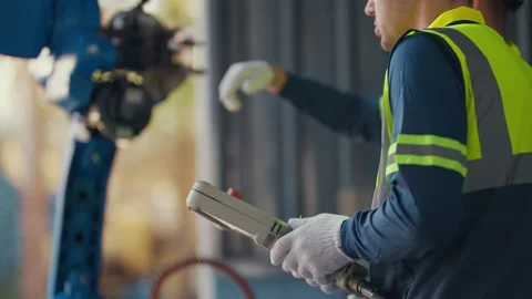 Worker controls robotic arm with handheld device 動画素材 344919572
