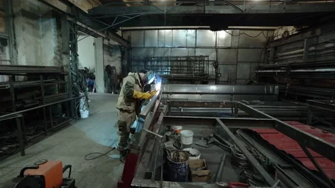 A worker cooks metal on a welding machine in production. a worker with a welding Stock Footage 178852664