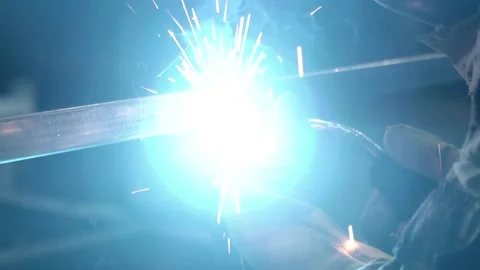 A worker cooks metal on a welding machine in production. a worker with a welding Stock Footage 178853945