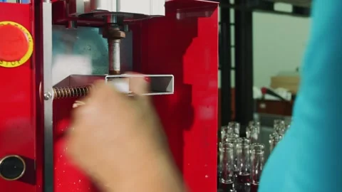 Worker corking wine bottles using automated machine in bottling facility Stock Footage 340637751