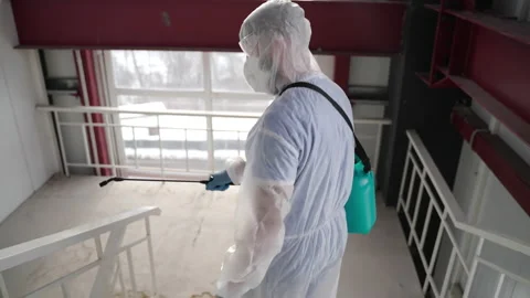 Worker in coverall disinfecting premises to stop spreading COVID-19 Stock Footage 157228208