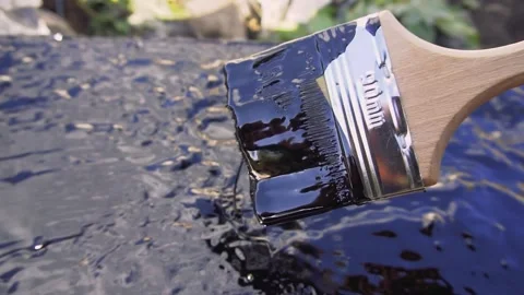Worker covered surface, bitumen primer for improving adhesion during surfacing Stock Footage 254064131