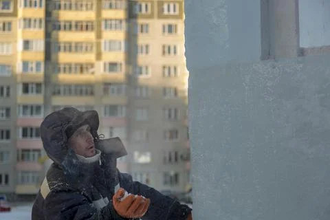 Worker covers the joints of ice panels with wet snow 스톡 사진