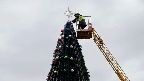 Worker on the crane install and decorate the Christmas tree. 스톡 동영상 83676905