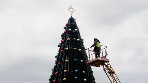 Worker on the crane install and decorate the Christmas tree. Stock-Footage 83676936