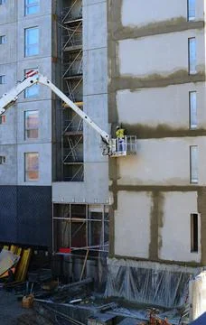 Worker on the crane plaster the wall Foto stock