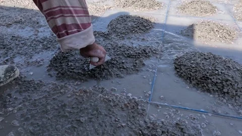 Worker Creating Decorative Stone Mosaic Flooring Pattern on Concrete Surface Stock Footage 347966041