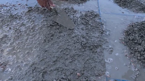 Worker Creating Decorative Stone Mosaic Flooring Pattern on Concrete Surface Stock Footage 347966290