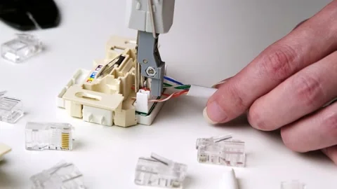 A worker crimping a network cable for an RJ45 module into a ethernet socket. Stock Footage 236457821