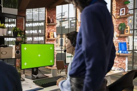 Worker in customer center using chroma key PC, installing software for clients 写真素材