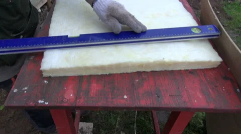 Worker cut mineral rockwool material for wall insulation Stock Footage 32222651