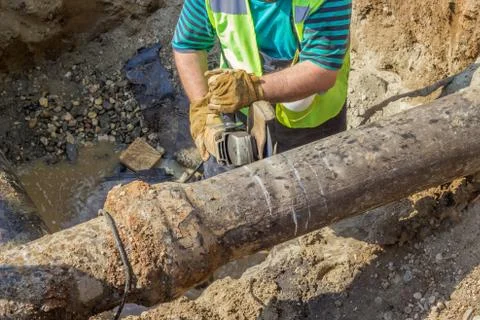 Worker cut section of water main Stock Photos