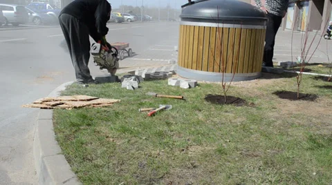 Worker cut small cement tiles with electrical hand held saw Stock Footage 32699900