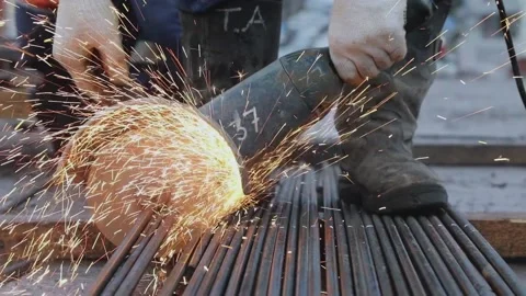 A worker cuts the armature by the circular saw in front of camera Stock Footage 131180177