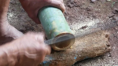 A worker cuts bamboo using a machete Stock Footage 310125979