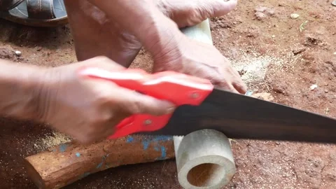 A worker cuts bamboo using a manual saw Stock Footage 310125415