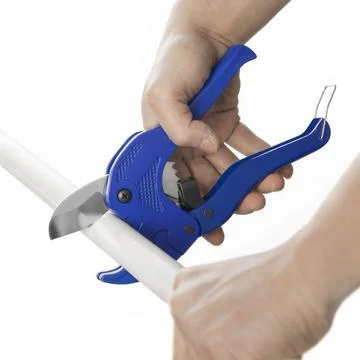 Worker cuts off a blue pvc pipe with blue pvc cutter on white background. Stock Photos