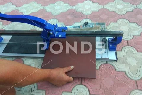 The worker cuts the ceramic tile on the manual tile Stock Photos
