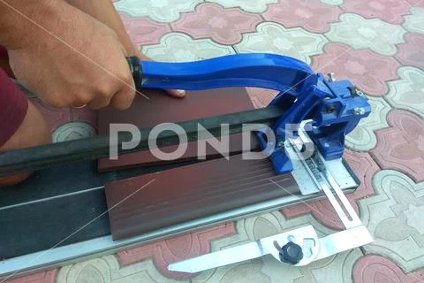 The worker cuts the ceramic tile on the manual tile Stock Photos