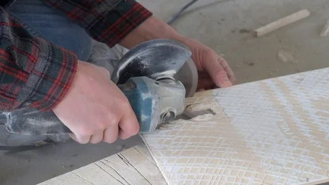 Worker cuts ceramic tiles with an angle grinder. A lot of dust Stock Footage 110606243
