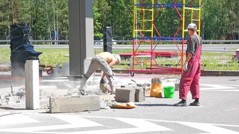 Worker cuts concrete blocks with power saw near road in Russia during the day in Stock Footage 326962879