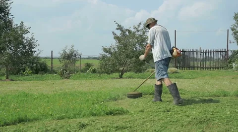 The worker cuts the grass with lawn string trimmer Stock Footage 67722751