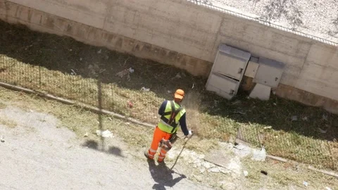 A worker cuts the grass with a mechanical tool Stock-Footage 196975741