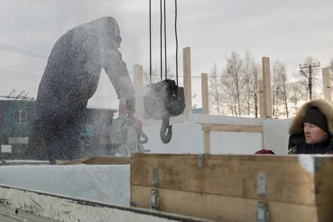 A worker cuts a hole in the ice panel with a chainsaw 스톡 사진