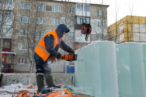 Worker cuts ice panel with gasoline saw 写真素材