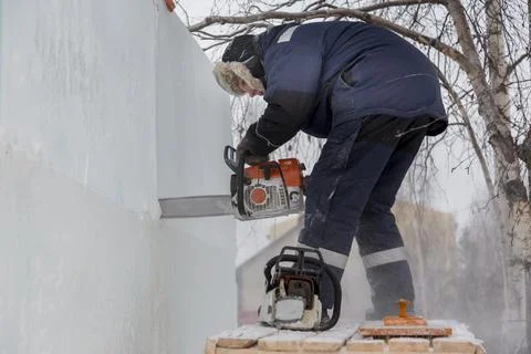 Worker cuts ice panel with gasoline saw 写真素材