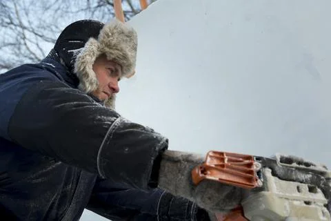 Worker cuts ice panel with gasoline saw 写真素材