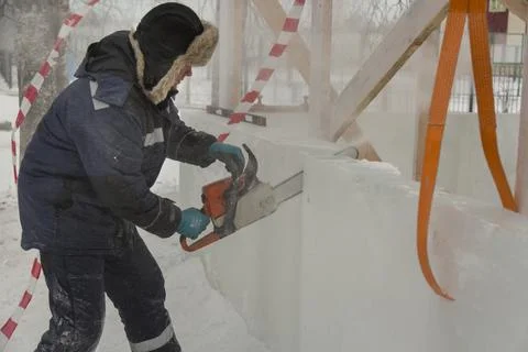 Worker cuts ice panel with gasoline saw 스톡 사진