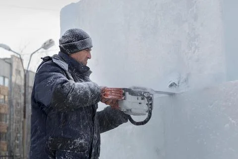 Worker cuts ice panel with gasoline saw 写真素材