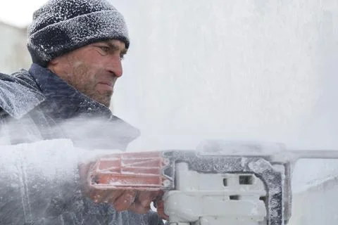 Worker cuts ice panel with gasoline saw Fotos Stock
