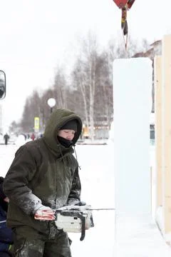 Worker cuts ice panel with gasoline saw 스톡 사진
