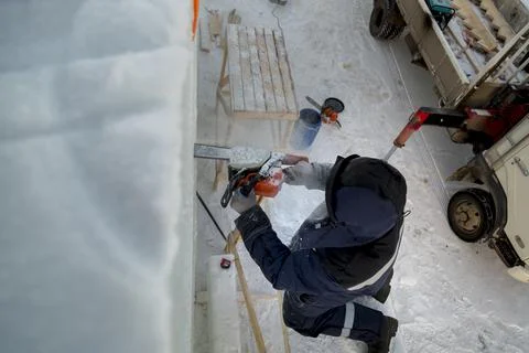 Worker cuts ice panel with gasoline saw 스톡 사진