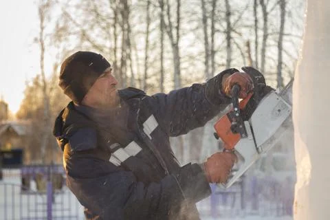 Worker cuts ice panel with gasoline saw 스톡 사진
