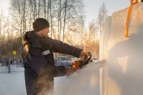 Worker cuts ice panel with gasoline saw Stock Photos
