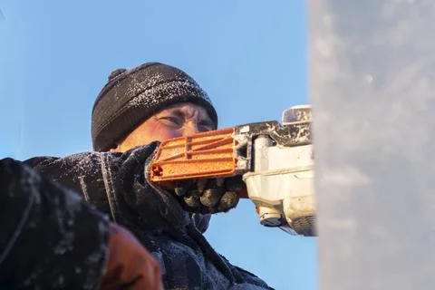 Worker cuts ice panel with gasoline saw 스톡 사진