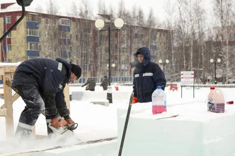 Worker cuts ice panel with gasoline saw 스톡 사진