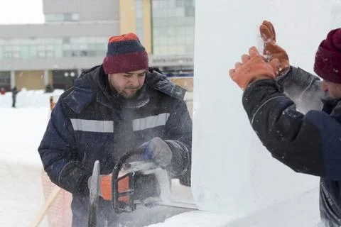Worker cuts ice panel with gasoline saw 写真素材