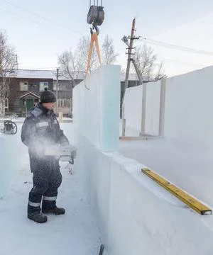 Worker cuts ice panel with gasoline saw 스톡 사진