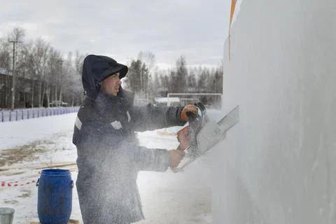 Worker cuts ice panel with gasoline saw 스톡 사진