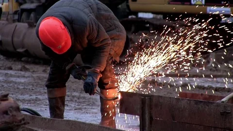 Worker cuts an iron beam with sparks Stock Footage