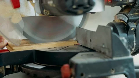 A worker cuts off a laminated board with an electric miter saw. Laying the floor Stock Footage 143448405