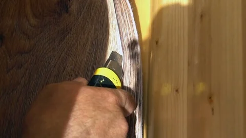The worker cuts off the linoleum with a utility knife,fitting of linoleum floor Stock Footage 77833466
