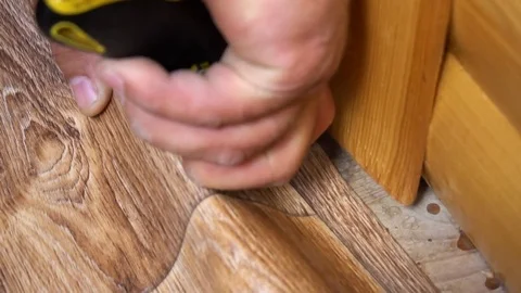 The worker cuts off the linoleum with a utility knife,fitting of linoleum floor Видео 77835769