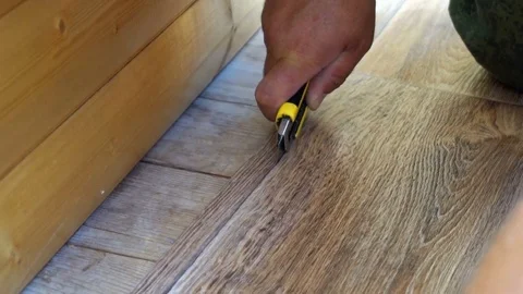 The worker cuts off the linoleum with a utility knife,fitting of linoleum floor Stock Footage 77836969